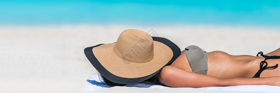睡着戴帽子旗帜的沙滩休闲妇女图片