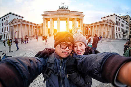 在带智能手机的年轻夫妇旅游自拍图片