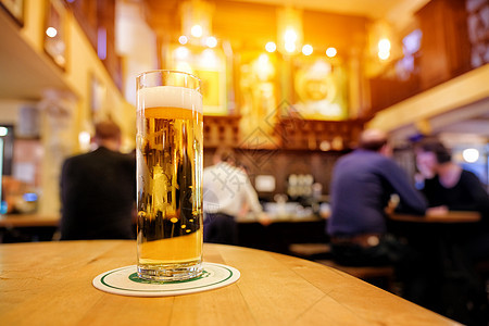 在酒吧的木制酒吧柜台 喝杯冷新鲜啤酒图片