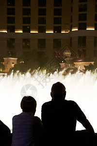 在拉斯维加斯欣赏贝拉吉奥喷泉奇观的人们剪影的夜景 反射 旅游度假区图片