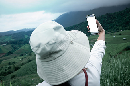 观光客享受大自然 用智能手机在Me上拍照图片