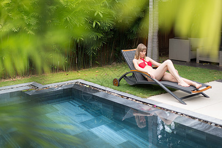 女人在泳池附近的上放松 奢华 椅子 宁静 旅游 财富图片