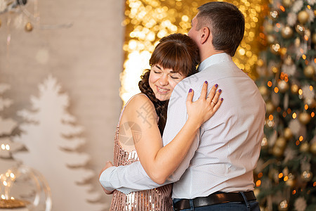 一个快乐的女孩在圣诞派对上 拥抱一个男人 在火花和雪兰中 庆典 成人图片