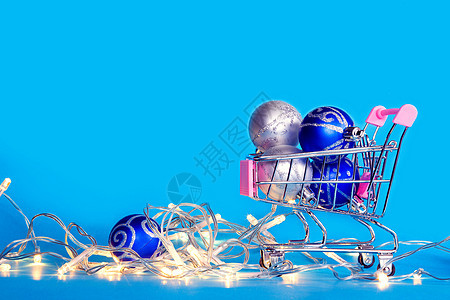 圣诞树球和圣诞节园地都躺在一辆购物车里图片