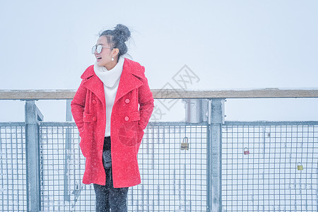美丽的年轻女子在户外的红皮大衣中玩雪 冬天图片