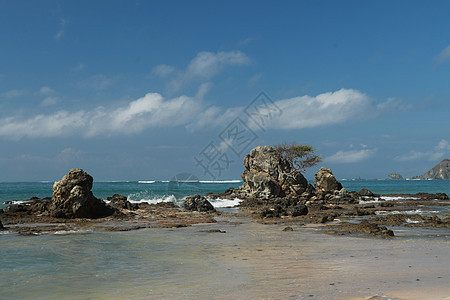 印度尼西亚龙目岛的田园诗般的海滩 Mandalika 海滩多石 许多岩层从水中冒出 库塔海滩上的岩层 完美的一天放松 海岸线 海图片