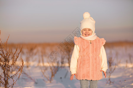 一个小女孩站在田地中间 在日落的冬天 在一个寒冬 美丽的 霜图片