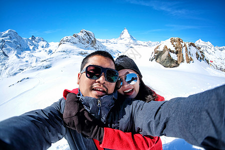 年轻夫妇旅游者自拍 在接近雪景的地方使用移动电话 阿尔卑斯山 天空图片