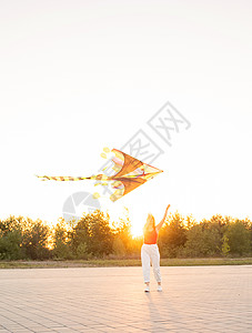 日落时 年轻女子在公共公园放风筝 喜悦 场地图片