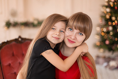 小女孩在圣诞树附近抱着妈妈 快乐的童年时光欢乐的时刻 圣诞节 喜悦图片