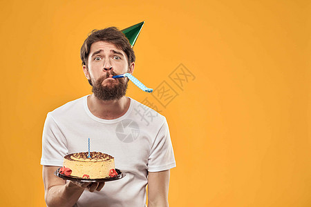 生日男孩在帽子和蛋糕的欢乐黄色背景派对上 惊喜 男人图片
