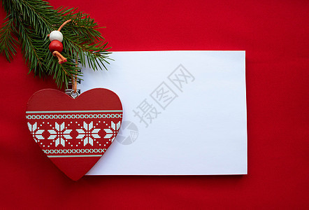 节日作文记事本 红色木心 白色装饰品和红色背景上的绿色杉枝 圣诞节和情人节概念 卡片 作品图片