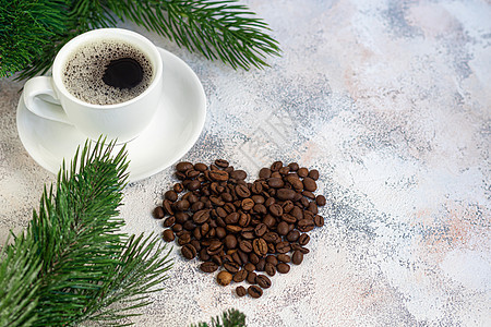 一杯香浓可口的咖啡 它被放置在由咖啡豆制成的基底上 新年假期概念 在浅色背景上 冬天 酸橙图片