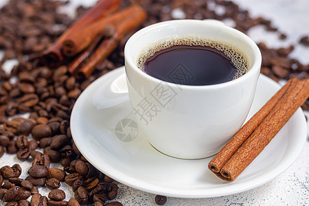 一杯香浓可口的咖啡 它被放置在由咖啡豆制成的基底上 新年假期概念 在浅色背景上 雪图片