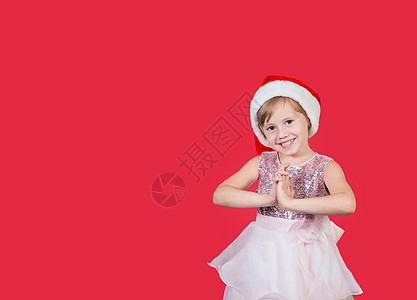 可爱可爱的笑笑女孩拍他的手 为一个孤立在红色上的礼物 孩子 纸图片
