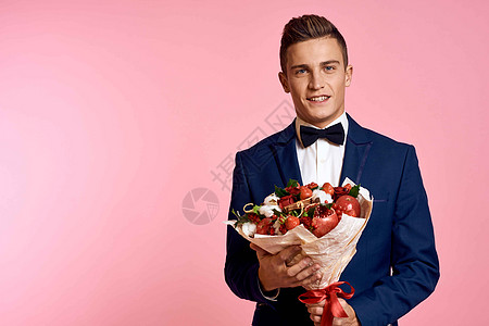 穿经典西装的帅哥 在粉红背景假日礼服领结模型上 一束鲜花 浪漫 生日图片