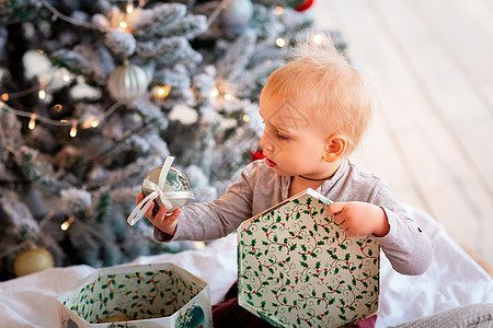 快乐的小宝贝男孩 在圣诞树附近打开礼物盒箱 假期 玩具图片