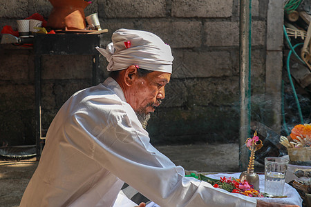 在印度尼西亚巴厘的登巴萨Ubud 举行Ngaben仪式的一名Balinese印度教高级牧师的近照 戏服 精神图片