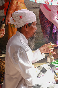 在印度尼西亚巴厘的登巴萨Ubud 举行Ngaben仪式的一名Balinese印度教高级牧师的近照 戏服 亚洲图片