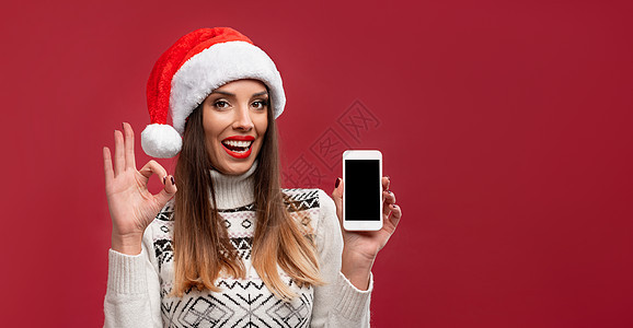 关闭肖像美丽的白种女人在红色工作室背景上的红色圣诞帽 圣诞节和新年假期的概念 脸 帽子图片