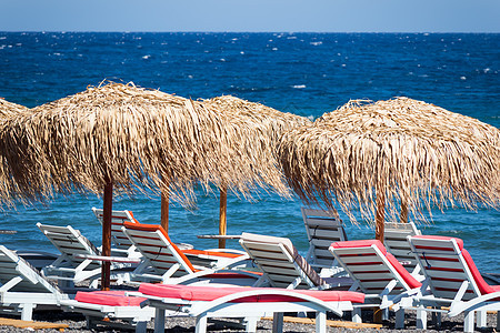 圣托里尼海边带雨伞和甲板椅的海滩 旅行 日光浴床图片