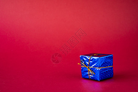 红色背景的蓝色假日礼品盒 复制空间图片