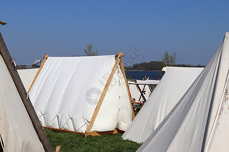 在蓝天前用木头和布织成的旧维京人帐篷 海盗帐篷背景图片