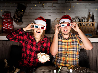 3D圣诞老人穿着3D眼镜的年轻夫妇 在圣诞节在家看电影 情绪 家庭背景