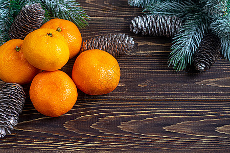 树枝和松锥上覆着雪 新年的构想是 在木制背景上的坦格林 Tangerines 有圣诞树枝和松果 薄荷 视锥细胞图片