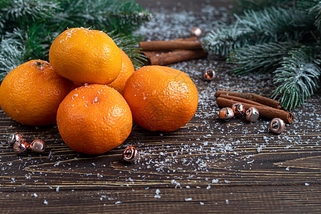 树枝和松锥上覆着雪 新年的构想是 在木制背景上的坦格林 Tangerines 有圣诞树枝和松果 夏天 鸡尾酒图片