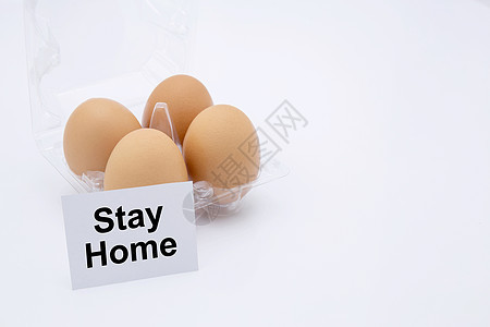 带文字的复活节彩蛋留在家里 以保护 covid-19 隔离在白色背景 社会距离和检疫中 为大流行性冠状病毒储备食物 复活节概念图片
