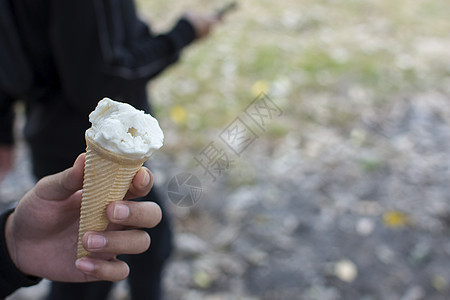 手握着模糊背景的冰淇淋白图片