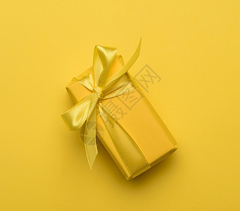 带有黄纸包着礼品的长方形盒 并绑有丝绸黄色丝带 生日 惊喜图片