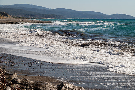 观察海岸线 希腊岛西边罗得斯有小石头沙滩和水浪 假期 欧洲背景图片