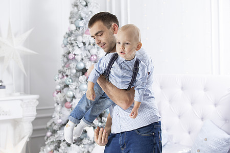 父亲和孩子在圣诞树的背景下玩耍 新年的人类和儿子 笑声 图片