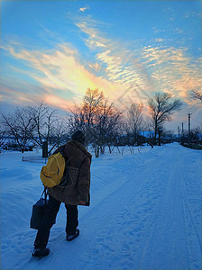 村里有雪覆盖的街道 一个男人走在街上图片