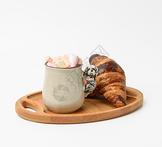 带有可可和棉花糖的陶瓷杯子 在木制供餐板上的烤羊角面包 舒适 饮料图片