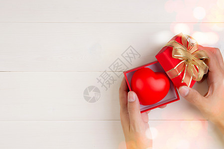 情人节 手开红色礼盒 心形木制白色背景 庆祝和周年纪念 给予爱 呈现浪漫和惊喜 节日和节日概念 丝带 木头图片