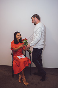 情人节快乐的一对夫妻 年中亚洲女人 与有红玫瑰和情书的cauusian男子 爱 成人背景图片