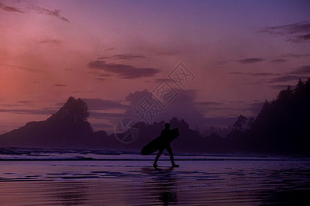温哥华岛托菲诺 海滩上的日落与海洋中的冲浪者 温哥华岛天空中粉红色和紫色的美丽多彩日落与流行冲浪 热带 太平洋图片