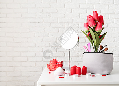 装有礼品盒 花朵和蜡烛的化妆品和温泉配件 放在布满复制空间的白砖墙壁背景上的梳妆桌前视图上 假期 管子图片