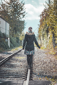 年轻漂亮女孩在铁路上保持平衡 旅行的概念是 度假者图片