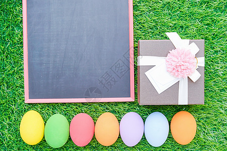 在草地和黑板模型上贴近复活节鸡蛋 快乐的图片