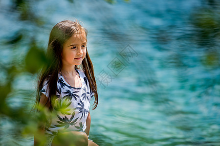 一位可爱的小姑娘坐在阿尔卑斯湖的岸边 在奥地利Plan See湖 甜的 支撑图片