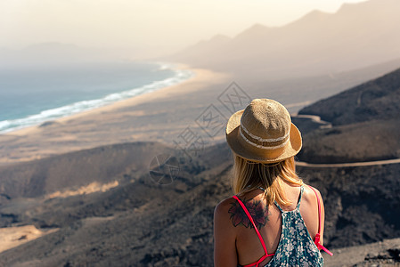 金发女孩看着西班牙富尔蒂文图拉 科菲特海滩的景观图片