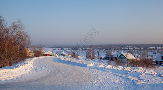 一个埋有雪的村庄 房子和一条动画路通向那里 冬季 天气图片