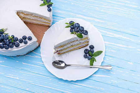 开胃的芝士蛋糕饼干枕头装饰着白色奶油蓝莓和薄荷 放在木制蓝色质朴的桌子上 烤的 可口图片