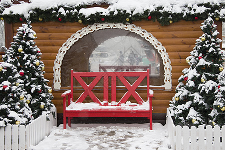 新年的风景 以树木和木屋为背景的红色长凳 新的一年的风景 木屋长凳圣诞树 圣诞节 阳台图片