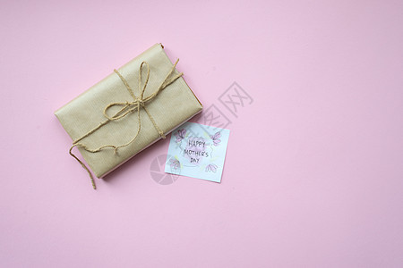 以棕色手工艺纸包着的礼物 和浅粉红背景的领带绳 母亲节礼物盒 顶级风景 装饰风格 女孩图片