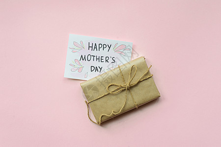 以棕色手工艺纸包着的礼物 和浅粉红背景的领带绳 母亲节礼物盒 顶级风景 柔和的 女性图片